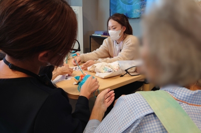 コミナス専従スタッフが病棟に入り、患者さんに寄り添う様子。