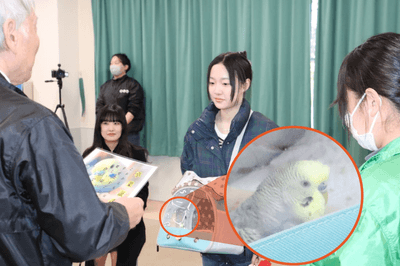 梶浦校長からルイスの卒業証書を受け取る奥山さん（中央）