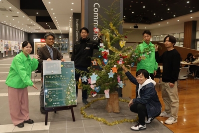 出来上がったツリーを披露する学生たち＝岡山キャンパスＡ1号館で