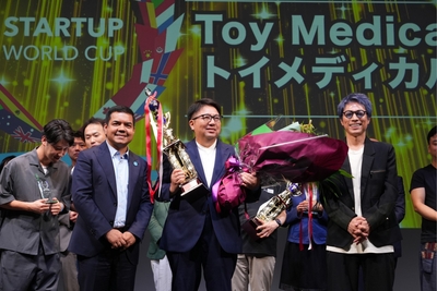 中央：スタートアップワールドカップ2025九州大会にて優勝トロフィーを持つトイメディカル代表 竹下英徳