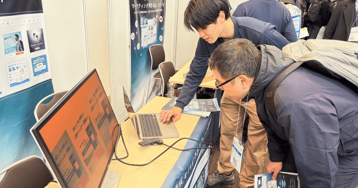 実際の画面を用いたデモンストレーションに真剣な表情で見入る来場者