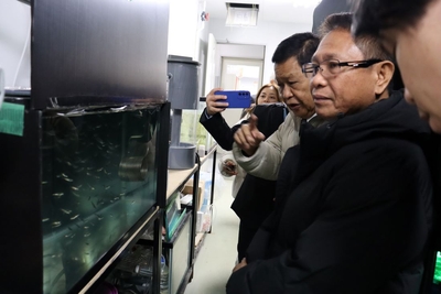 ベニザケとなるヒメマスの稚魚に見入るルイナタ統括部長（右から2人目）ら