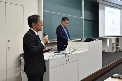 森特任教授を紹介する薬学部の岡本浩一教授（左）