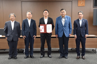 功労賞に選ばれた塚越教授（中央）を囲む小原学長ら