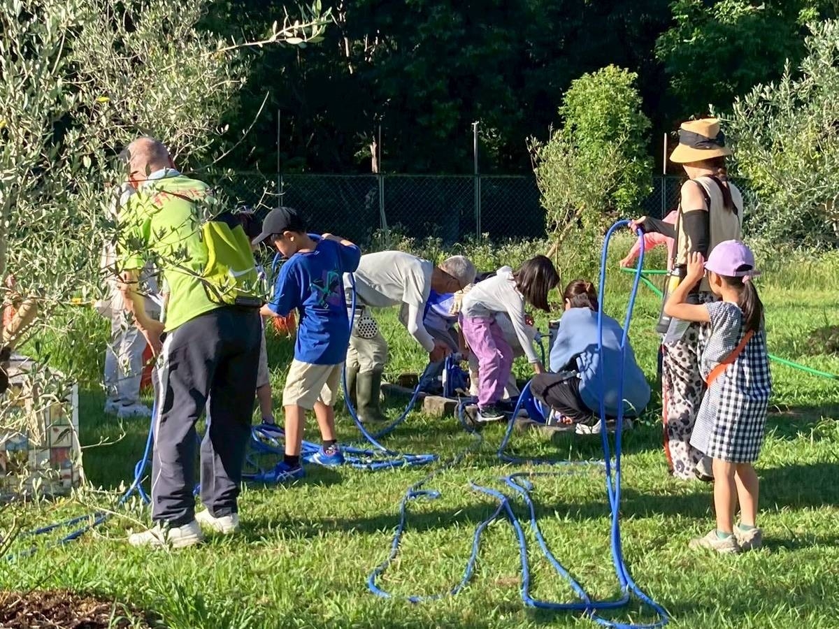 夏休みのラジオ体操後に地域の方と一緒に水やり。