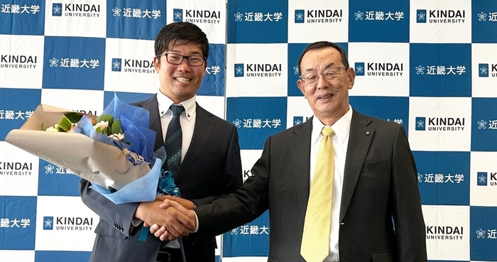 会見での花束贈呈 古川高晴(左)、近畿大学体育会洋弓部監督 山田秀明(右)