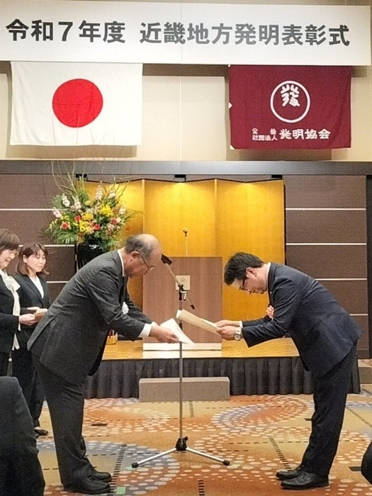 賞状贈呈の様子(左:大阪発明協会会長、右:発明者 足立 将司)