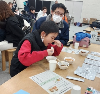 国際宇宙ステーションでの味覚を再現するため、鼻をつまんで食べている様子