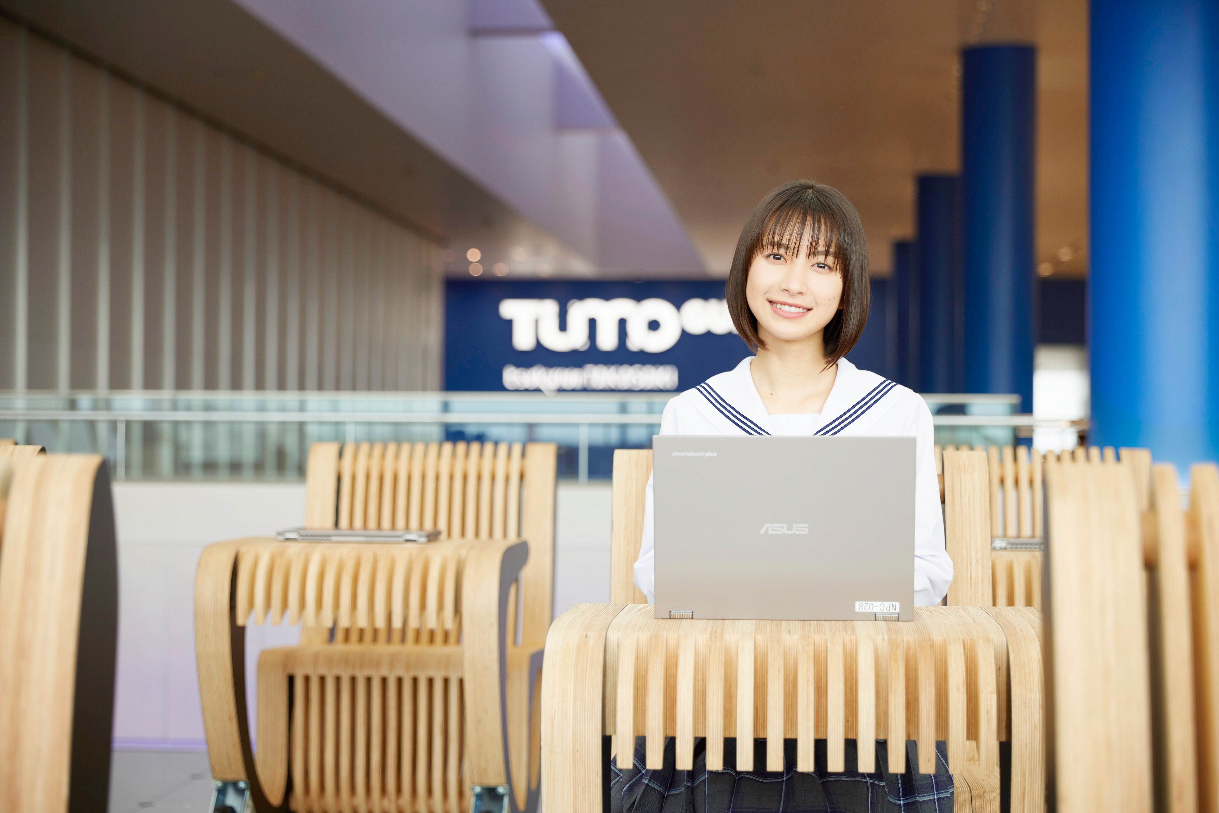 TUMO Gunmaに設置された机と椅子が一体となったオリジナル家具「TUMOBILE」に座るアンバサダーの藤崎ゆみあさん ※藤崎ゆみあさんの「崎」は立つ崎(たつさき)が正式表記。以下も同様