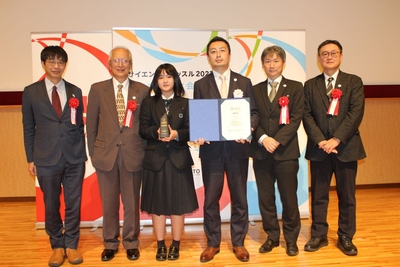 口頭発表で最優秀賞を受賞し、審査員とともに記念写真に納まる門田さん（左から３人目）