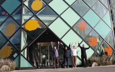 カッティングシートの取り付けが完了して喜ぶ学生たち。右端が石垣館長