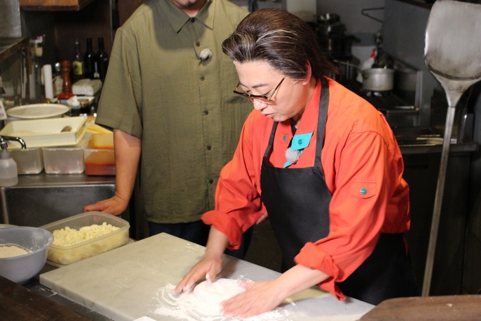 器用にピザをこねる西尾一男