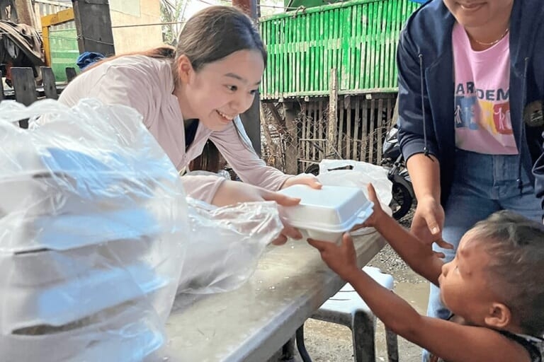 フィリピン・セブ島の貧困地域で暮らす子どもに食事を支援する様子