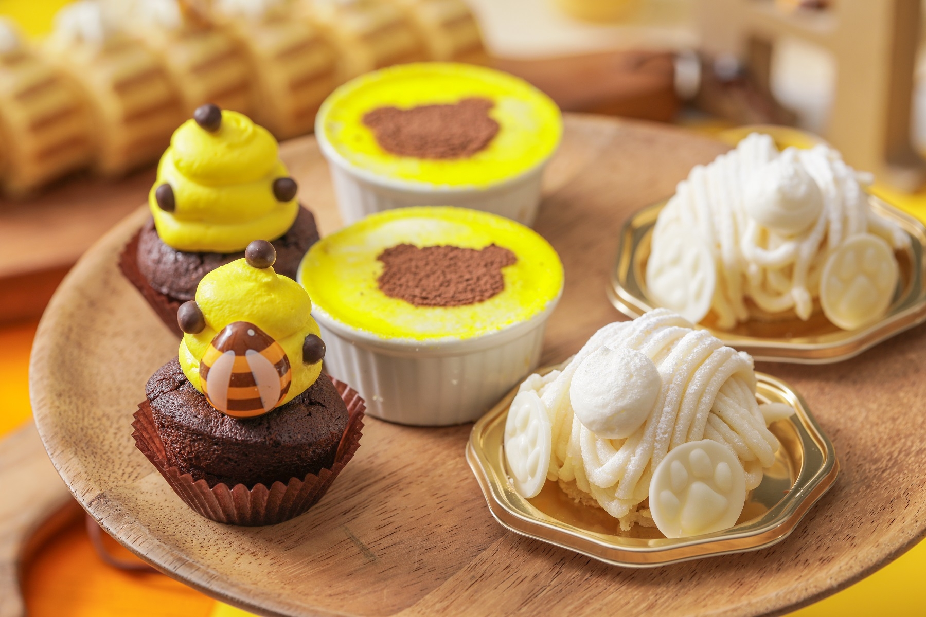 (左)チョコチップマフィン:はちの巣をイメージしたチョコチップの食感を楽しめるマフィン。 (中)くまさんスタンプのティラミス :チーズの濃厚な味わいとほろ苦いコーヒー味が程よいティラミス。 (右)しろくまモンブラン:白あんのクリームと、かのこ豆を合わせ和テイストのモンブランは白熊のお尻に見立て可愛らしい仕上げに。