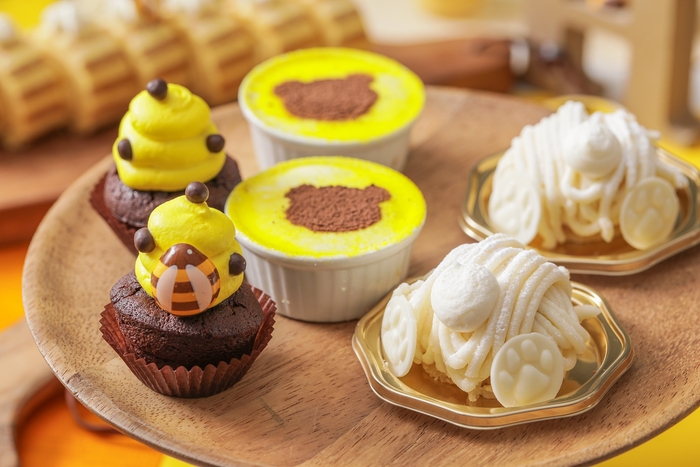 (左)チョコチップマフィン:はちの巣をイメージしたチョコチップの食感を楽しめるマフィン。 (中)くまさんスタンプのティラミス :チーズの濃厚な味わいとほろ苦いコーヒー味が程よいティラミス。 (右)しろくまモンブラン:白あんのクリームと、かのこ豆を合わせ和テイストのモンブランは白熊のお尻に見立て可愛らしい仕上げに。