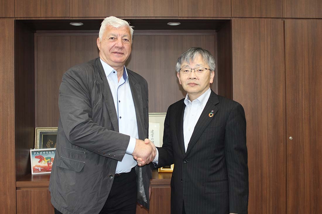 平野学長(右)とがっちり握手するディミトロフ市長(左)