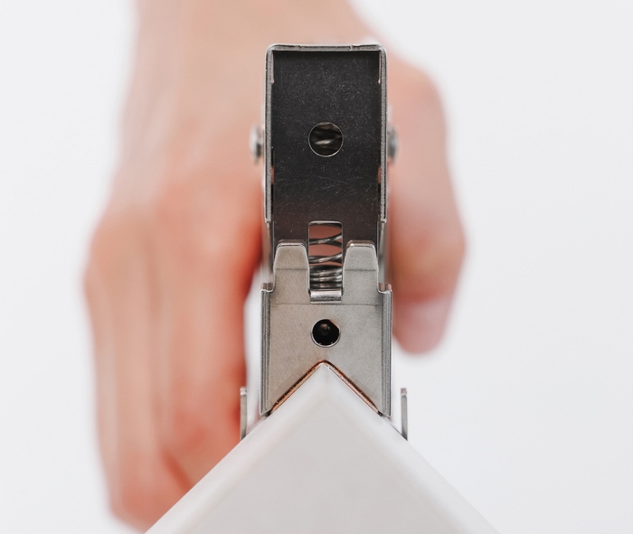 ホッチキスを角に打ち込む様子