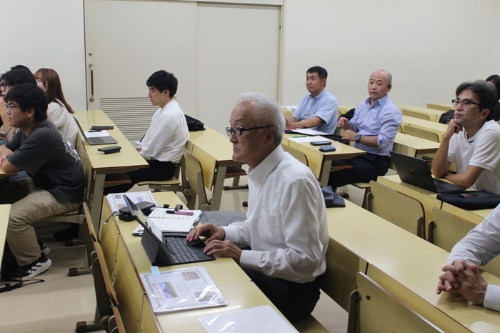 学生たちの報告に聞き入る宮下客員教授(中央)ら