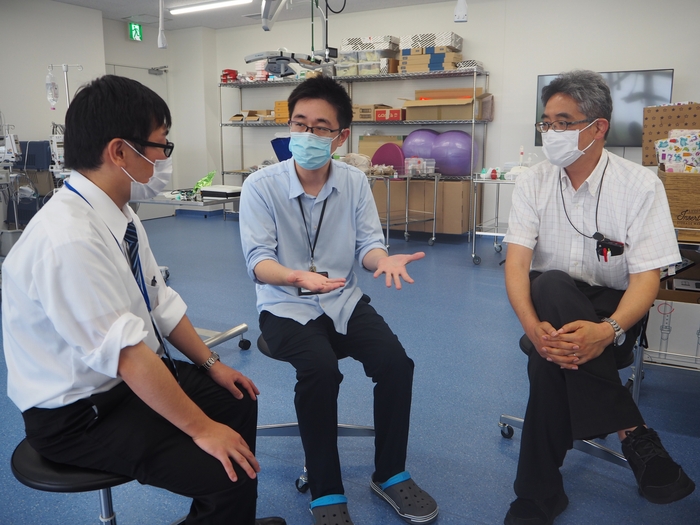 情報理工学科の赤木教授(右)、横田雅司助教(左)と打ち合わせる宮部助教(中央)