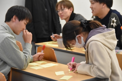 個人ワークでアイデアを出し合う学生たち