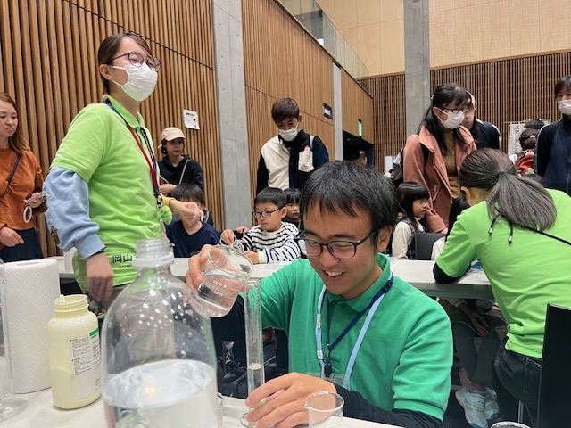 科学ボランティアセンターの登澤さん(左)と鈴木さん(中央)はうれしい悲鳴を上げながら懸命に対応