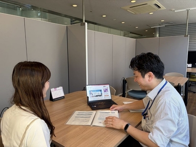 資料を見せながら民間事業者へ説明する区職員の様子