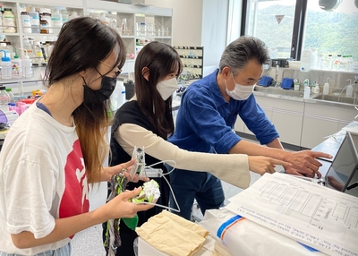 学生たちにデバイス操作の説明をする水野教授（右端）