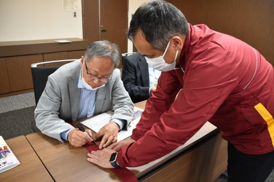 メッセージを書き入れる野口学長