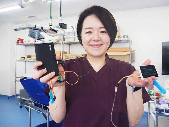 新旧の包帯巻圧測定器を手にする佐伯講師。(右側が新型)