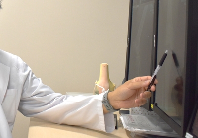 骨の状態を確認しながら、継続的な評価の必要性について説明する診療場面（イメージ）