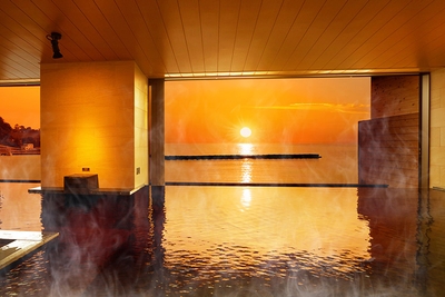 水面を黄金色に染める水平線に沈む夕日