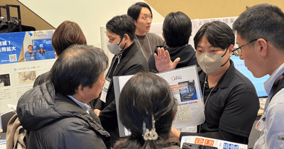 資料を囲み、熱心に導入相談を行う出展者と来場者の姿