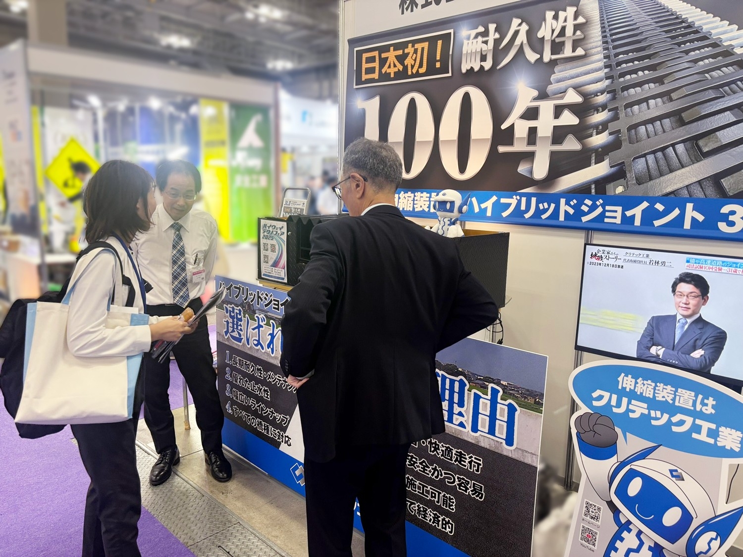 展示ブースでスタッフが製品説明。来場者は製品の特長や性能に高い興味を示した