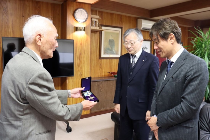 勲章を披露する善木名誉教授(左)