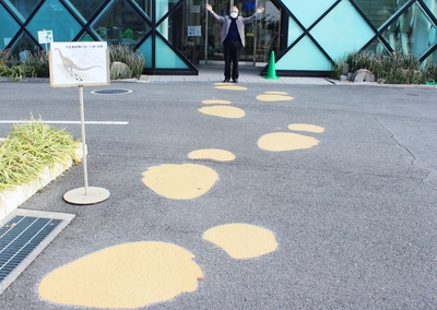 大型恐竜の足跡出現！（後方は石垣館長と50周年記念館）