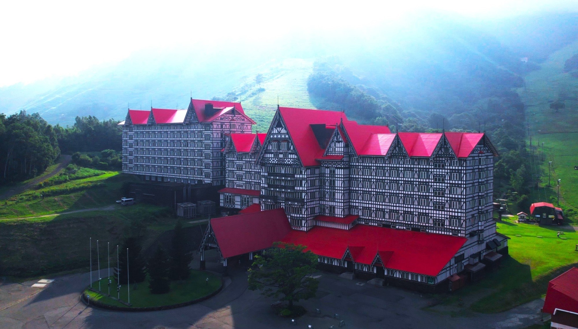 春の息吹に包まれた赤い三角屋根のホテルグリーンプラザ白馬