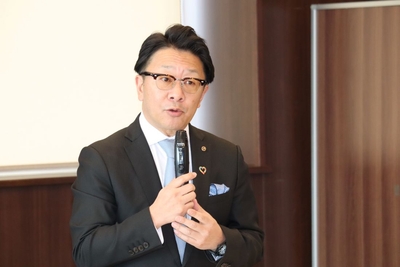 調印後、あいさつする尾崎会長