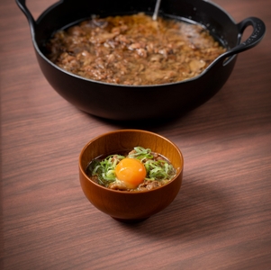 大阪の味 牛スジ煮込みは、トッピングに味付け卵黄やネギ、七味をご用意。