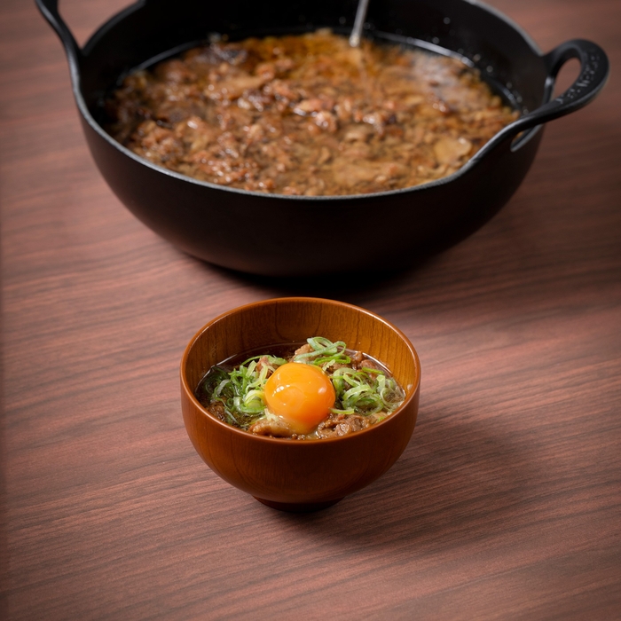 大阪の味 牛スジ煮込みは、トッピングに味付け卵黄やネギ、七味をご用意。