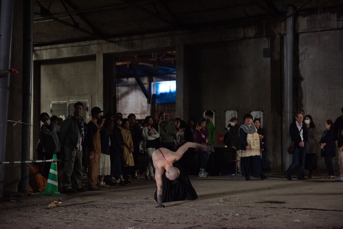 巨大なサルベージ倉庫で行われた公演。観客を引き連れながらパフォーマンス。