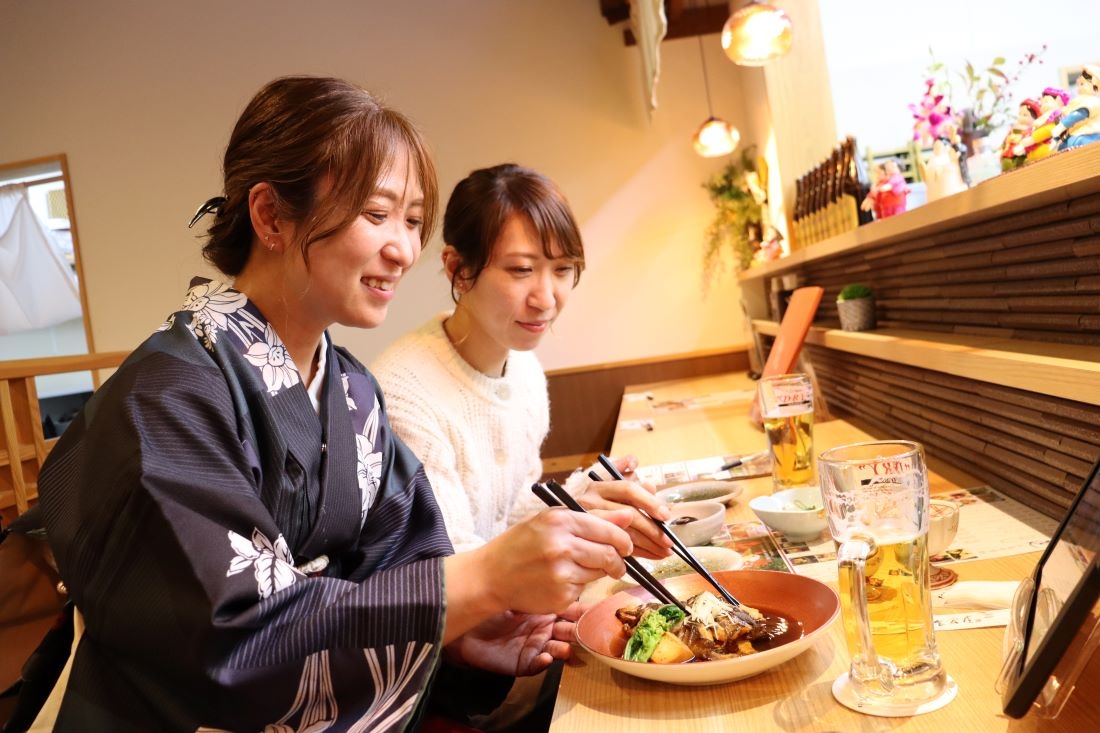 メバルの煮付けに舌鼓を打つ女性客