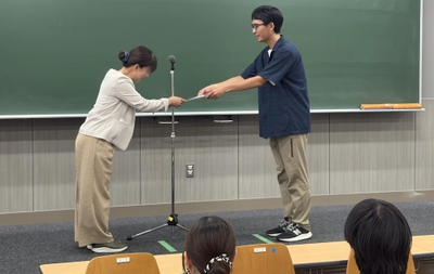 伊藤センター長から助成決定通知書を受け取る学生