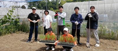 近畿大学農学部の実験圃場での実習の様子。近畿大学農学部の学生（後列）と桂高等学校の生徒（前列）
