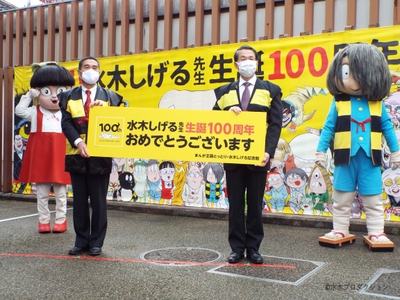 「水木しげる生誕１００周年お祝いペストリー」お披露目式の様子（左から、ねこ娘、境港市長 伊達憲太郎、鳥取県知事 平井伸治、ゲゲゲの鬼太郎）