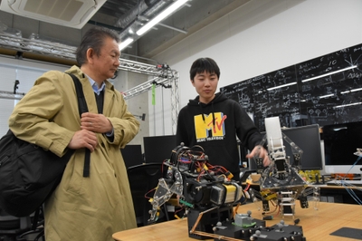 池本研究室でロボットを手に説明する学生