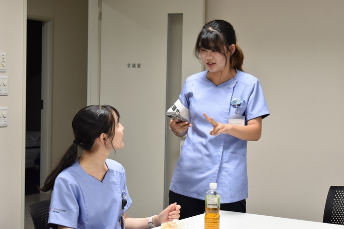 スマートフォンを片手に、言葉の壁を越えて笑顔で談笑する様子