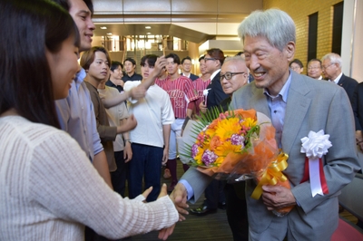式後、学生たちと握手する長谷川顧問