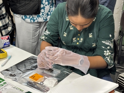 指示を受けながら試料の取り付けを練習するインドの学生