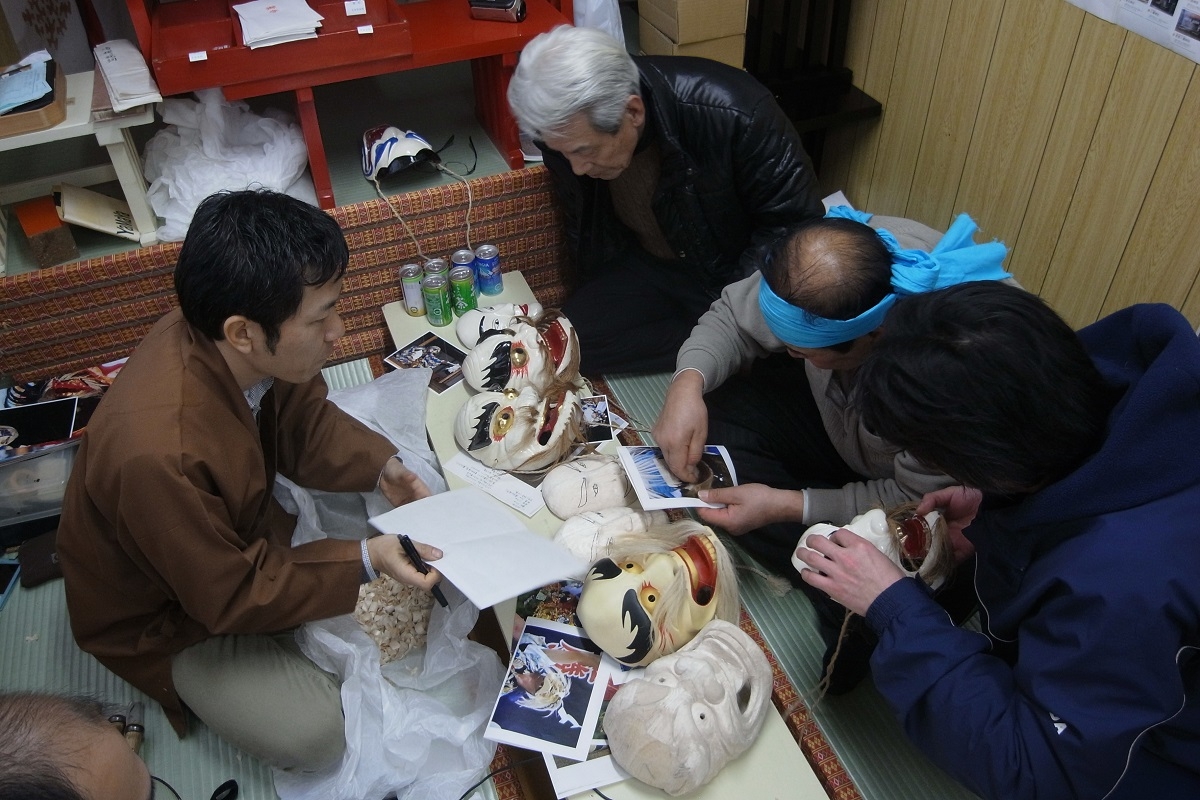 面再生のために仮彫面の修正点を検討する神楽師