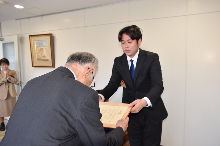 目録を手渡す長谷さん